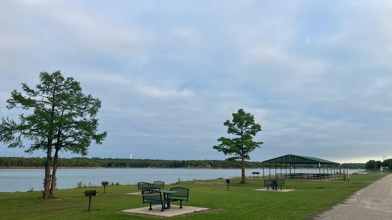 Picnic tables and grills on the shore of Lake Carl Blackwell.