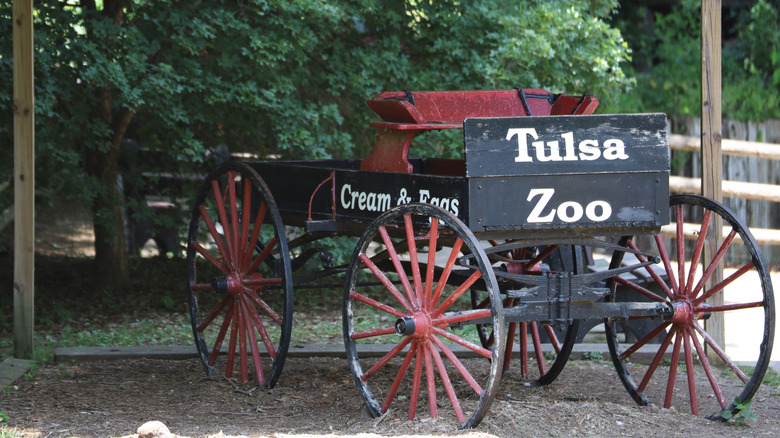 The entrance of the Tulsa zoo, with a black-and-white sign on an old bugy