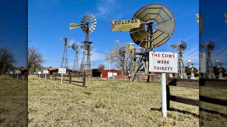 Various windmills against a blue sky at Shattuck Windmill Museum