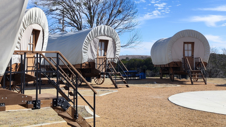 A half-circle of covered wagons that are glamping campground sites for overnight guests at Turner Falls State Park