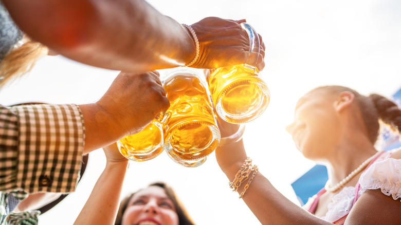 Four friends clinking glasses with beer at Oktoberfest
