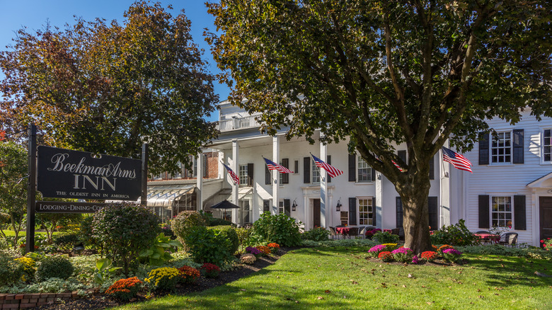 The front of the Beekman Arms Inn, a white colonial-era building with American flags flying from its columns
