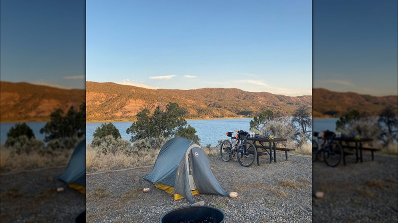A small tent with a mountain bike and picnic table at sunset in Navajo State Park