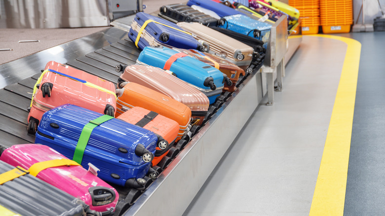 Brightly colored bags on an airport luggage carousel