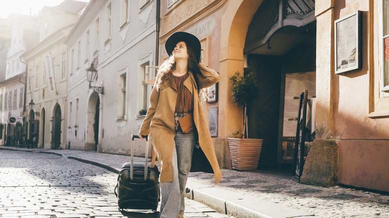 A woman traveler winding down Europe's cobbled streets with her luggage