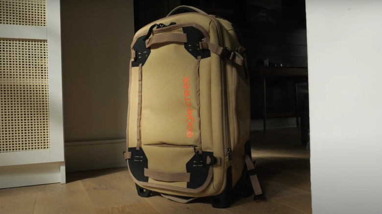 An Eagle Creek Gear Warrior XE Convertible Carry-On held with its sturdy straps