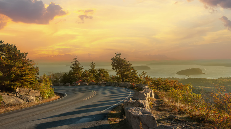 Road on the slopes of the mountains overlooking the bay of the Atlantic Ocean and the islands in the sunset light. Acadia National Park. USA