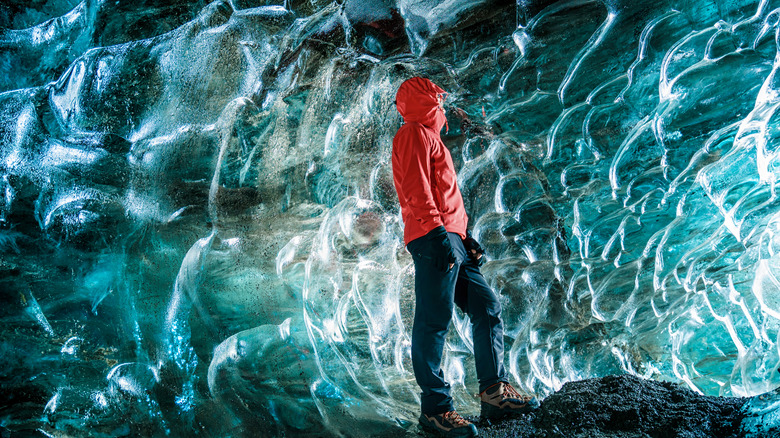 Person standing in a blue ice cave in the Mendenhall Glacier, Alaska