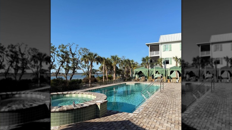 Exterior of The Dunlin, pool area with river view and cabanas