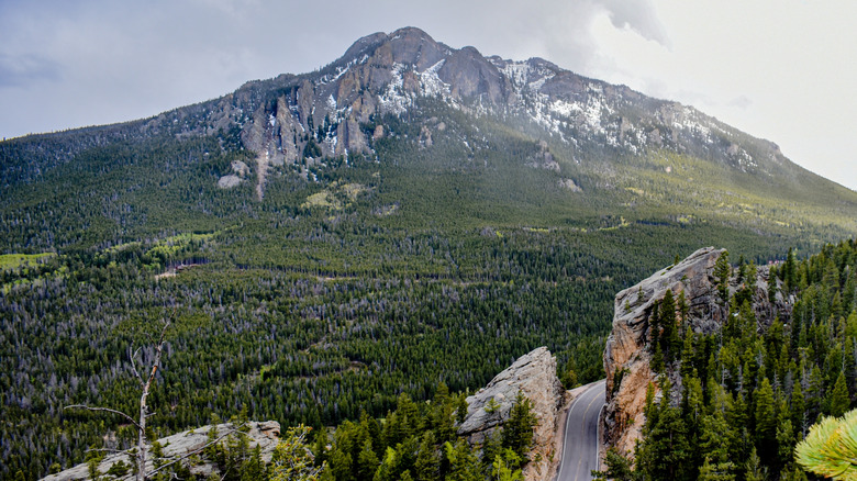 A mountain view with a road and sheer cliffs in the foreground