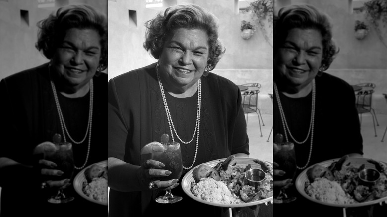 Ninfa Laurenzo holding a drink and plate of food