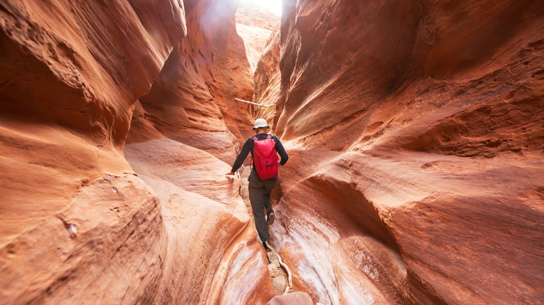 Hiker traversing a slot canyon
