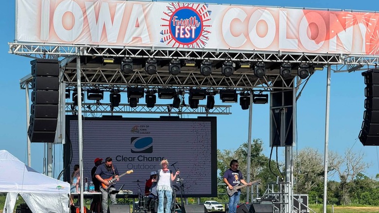 A band performs on stage at a festival in Iowa Colony.