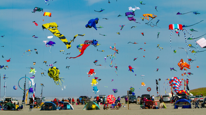 Kites flying and tents on the beach at the Washington State International Kite Festival