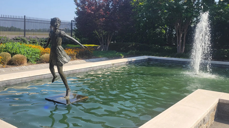 An outdoor garden at Greenville-Spartanburg International Airport with a fountain adorned with a statue of a girl