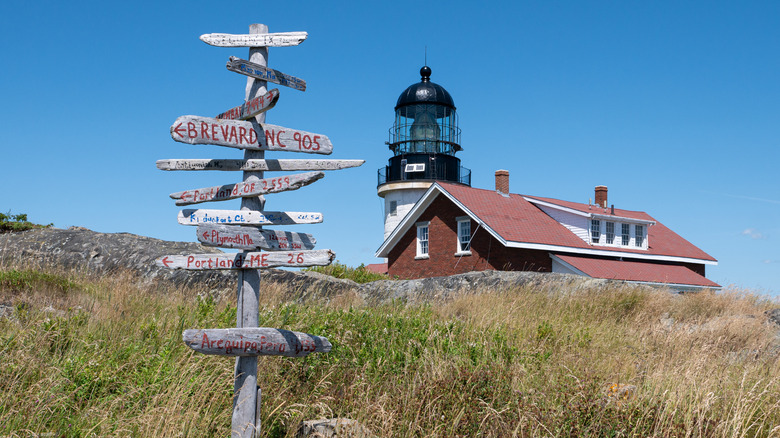 A signpost with the Seguin Island Lighthouse in the background