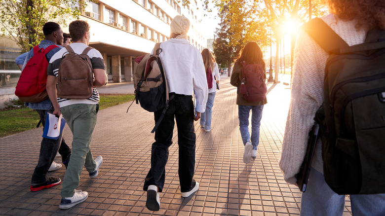 Students arriving at school in sunshine