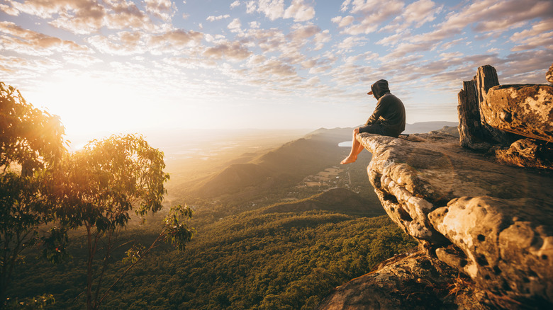 Hiker sitting on a rock outcrop with a view