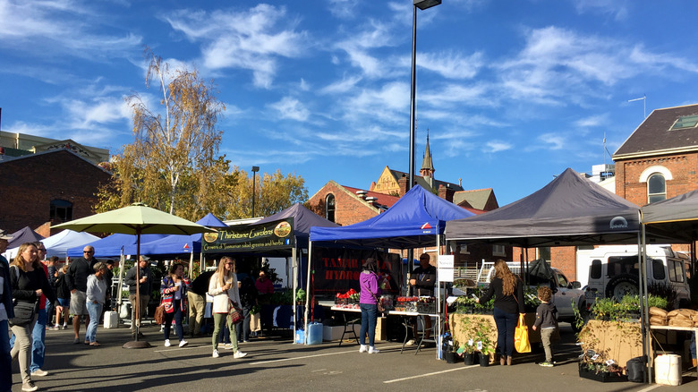 People strolling through market stalls on a sunny day