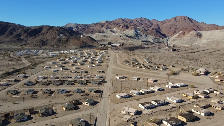 abandoned houses beneath red gray mountain