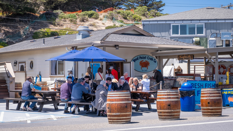 People eating and chatting at picnic tables outside Spud Point Crab Co. in Bodega Bay