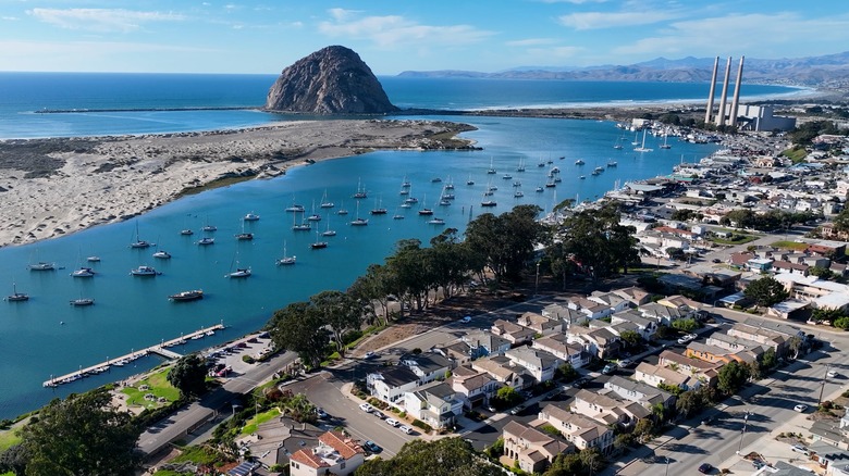 Aerial view of houses and the marina in Morro Bay with Morro Rock looming in the background