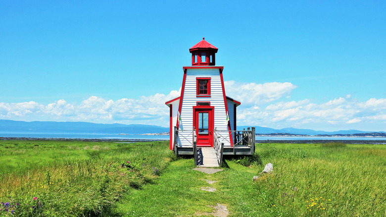 Red-trimmed lighthouse by the shore of Kamouraska, Canada