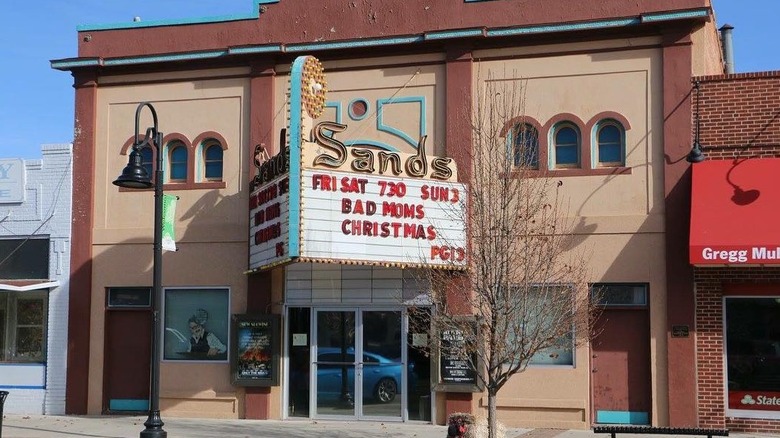 A historic theater with brown and blue walls and a red marquee