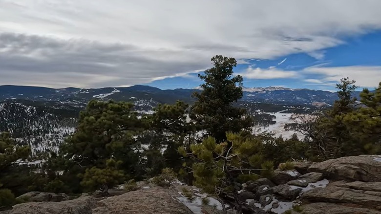 scenic panorama of mountains, meadows and pine trees and blue sky