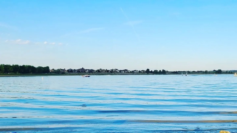 Thee blue waters of Boyd Lake form gentle waves, while a boat floats in the distance