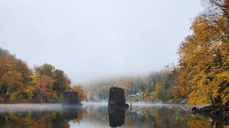 Mist rises from the tranquil waters of Lake Zoar in Connecticut on a gray autumn day