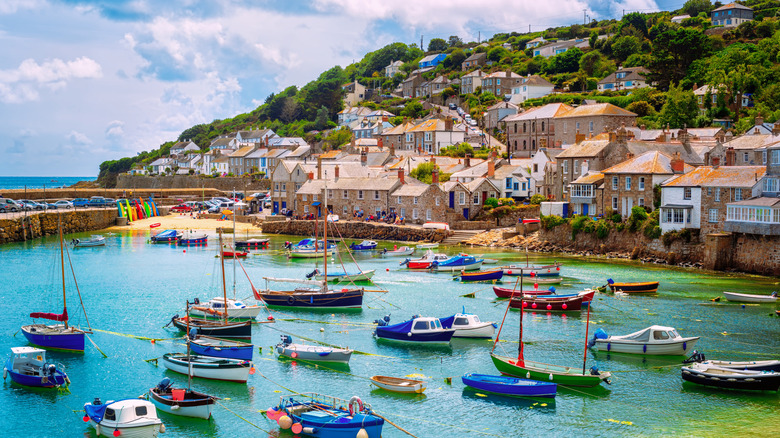boats on the water with houses on the shore in Mousehole, Cornwall
