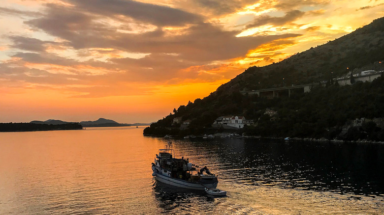 A boat on the water by Sveti Jakov Beach in Croatia at sunset