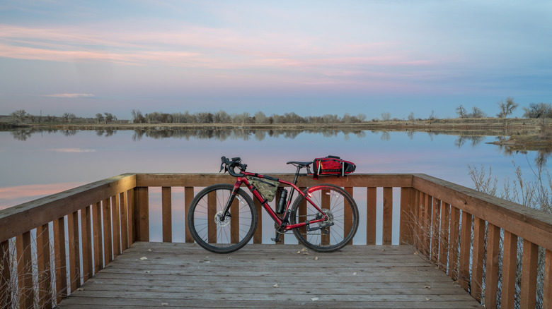 gravel touring bike with lights on at a lake shore at dusk in northern Colorado near Brighton