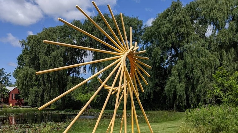 A yellow abstract sculpture in a sculpture park
