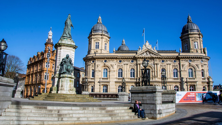 Historic building in Hull with ornate domed roofs and a statue in front