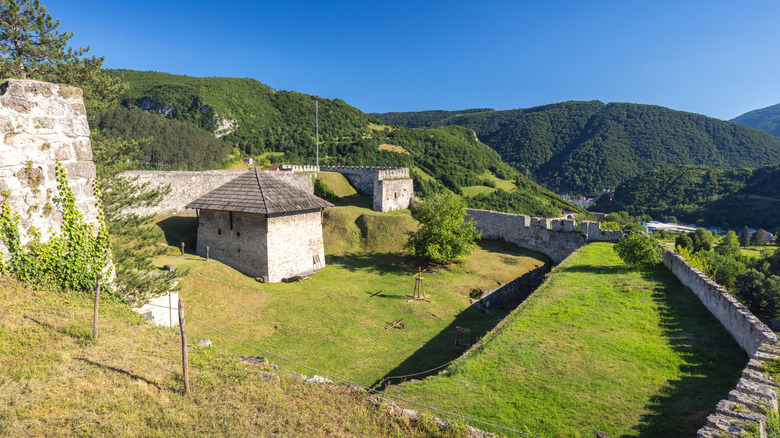 The medieval fortress of Jajce with green hills in the background
