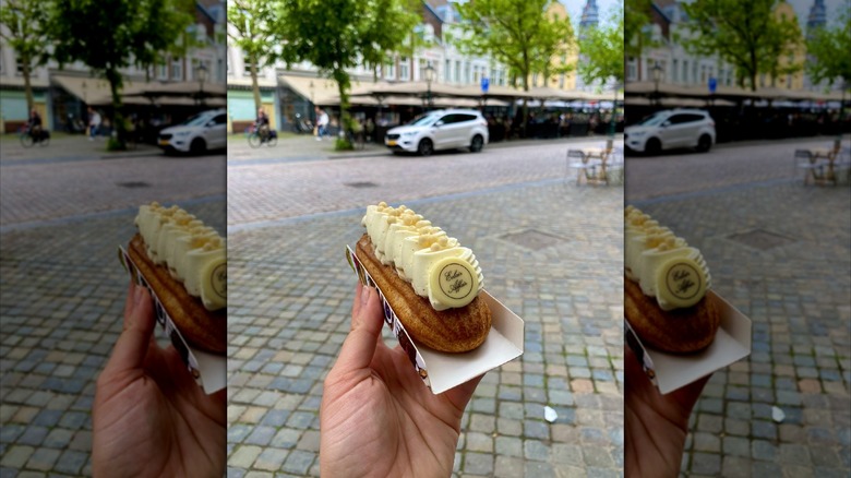 An hand holding an eclair