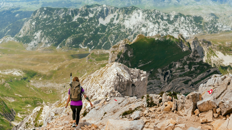 A woman hiking down from the summit of Bobotov Kuk