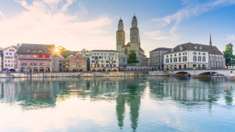 The sun rising over Zurich's buildings and the Limmat river in Switzerland