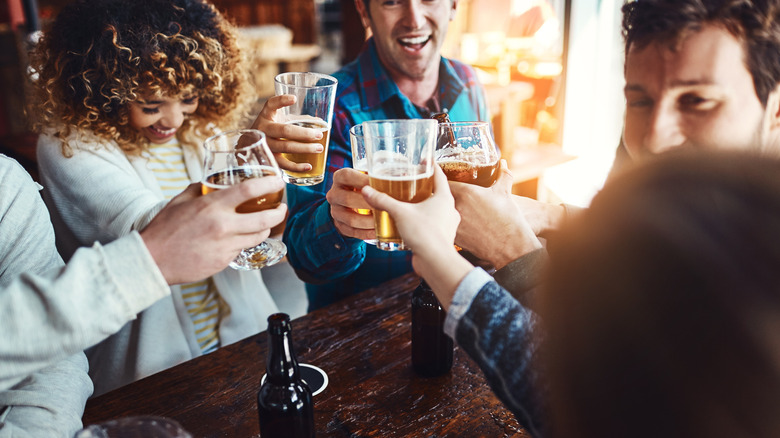 People clinking their glasses with beer