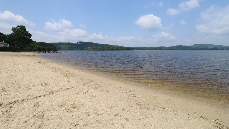 A wide and long stretch of sand beach and clear water at Lac de Vassivière