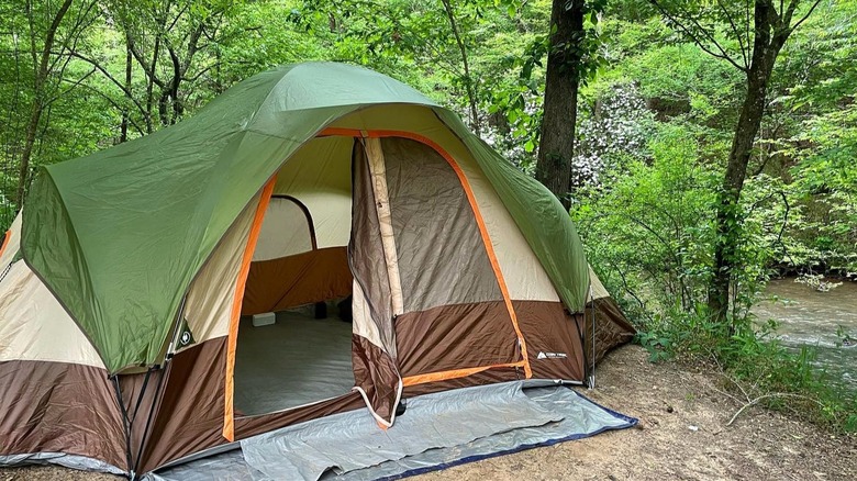 A large green, brown and tan tent overlooking the river and the green woods at Watson Mill Bridge State Park, in Georgia.