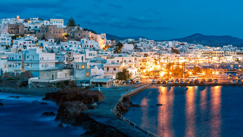 Whitewashed homes on a hill in Naxos illuminated at dusk in the Aegean Sea, Cyclades, Greece