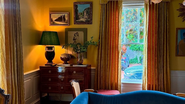 A corner in the lounge of The Marlene with antique furniture and curated artwork on the walls