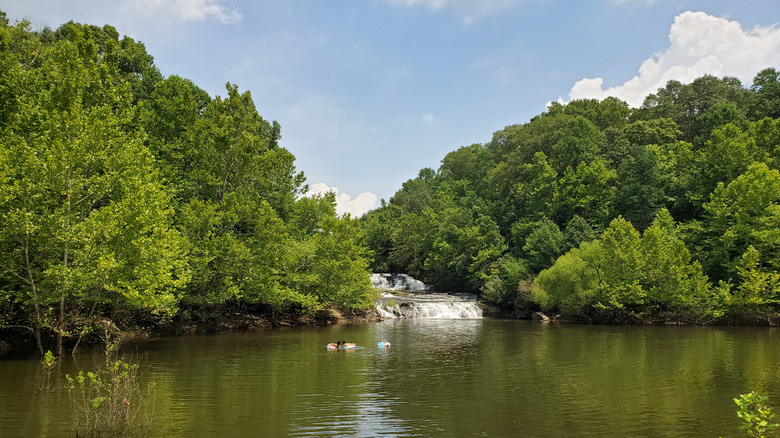 Lake Kinkaid surrounded by trees with a waterfall in the background