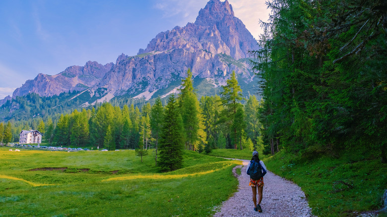 The path crosses a meadow at the start of the Lago di Sorapis hike