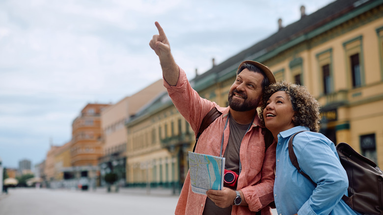 Couple traveling in Italy pointing at monument