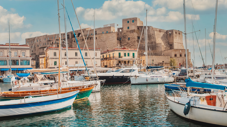 The Naples harbor full of sailboats in front of the Castel dell'Ovo, Italy