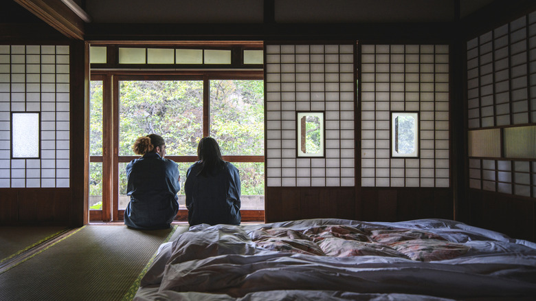 Two guests in a traditional Japanese inn, ryokan, with tatami mat and futons